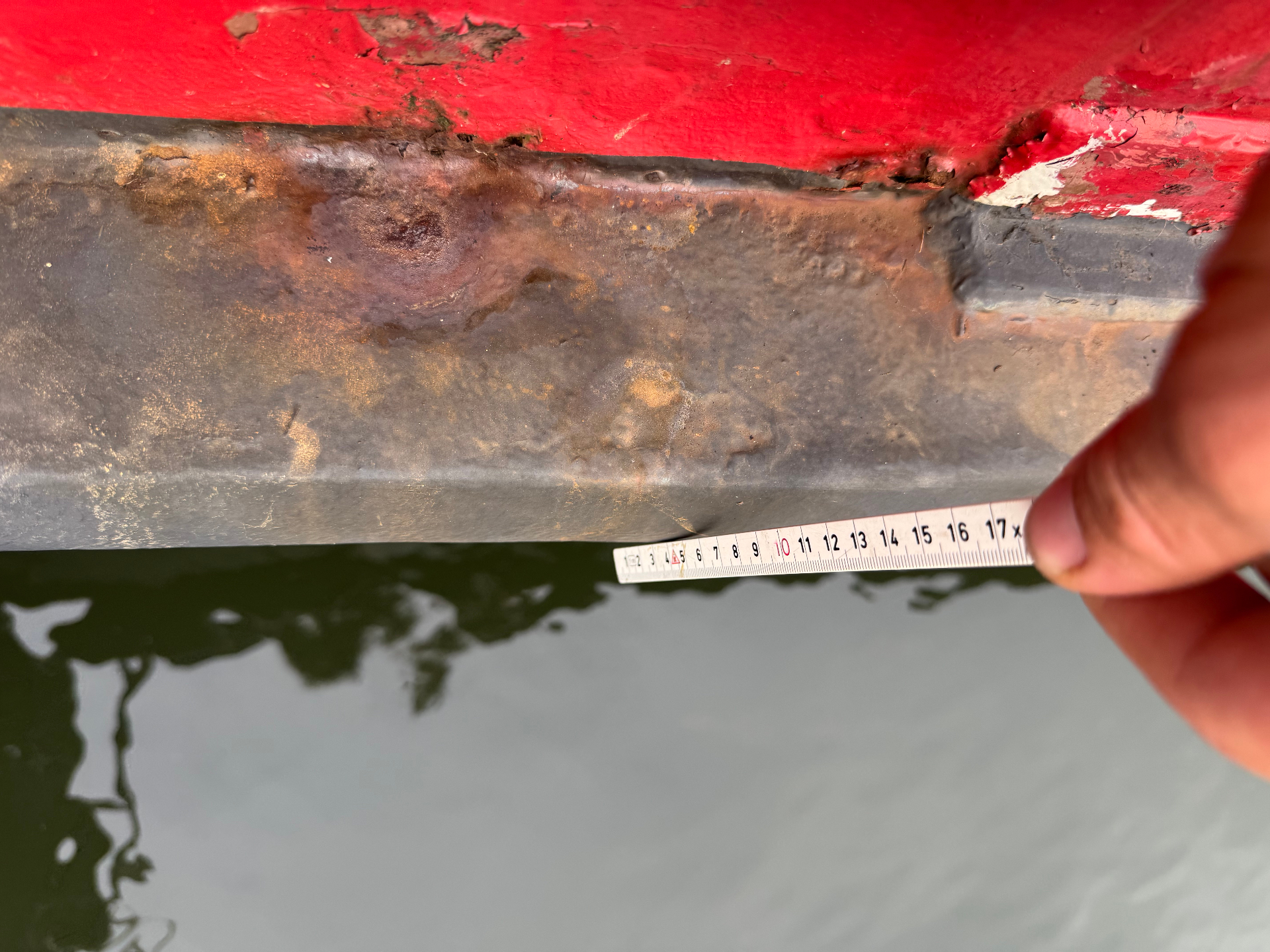 Doorgeroest berghout van een woonschip, opgemeten met een rolmaat